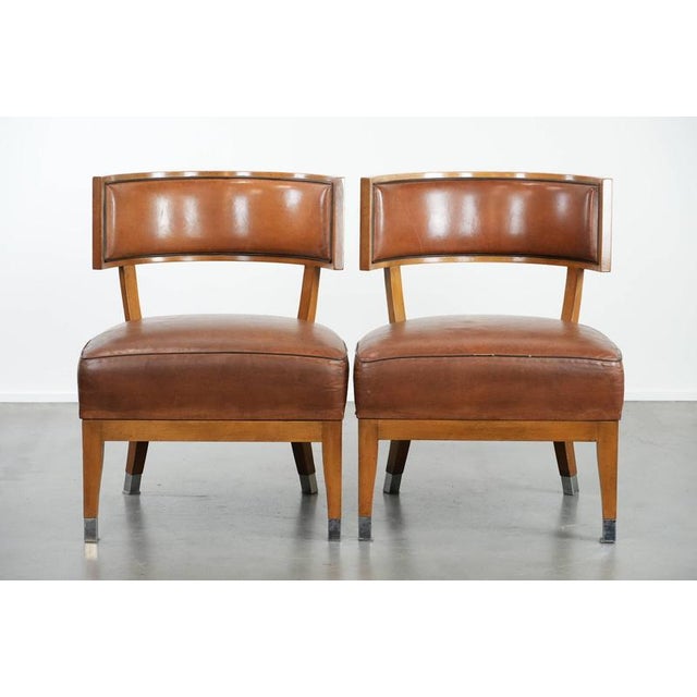 This set of four vintage designer armchairs/cocktail chairs made of sheepskin leather with a unique design. : This set of...