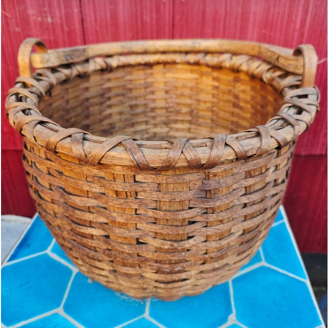Antique hand-woven wood splint swing-handle basket, dating to the late 19th century, featuring a round body with a...