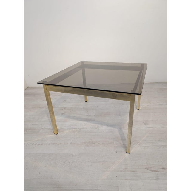 An elegant coffee table from the 1970s/80s, featuring a timeless vintage style. The table features a solid, brass frame...