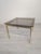 An elegant coffee table from the 1970s/80s, featuring a timeless vintage style. The table features a solid, brass frame...