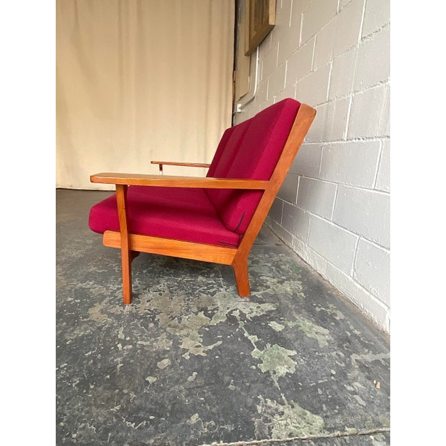 Elegant and commodious, here we have a rare example of Wegner’s celebrated GE-330/3A three seat sofa in carved teak frame...