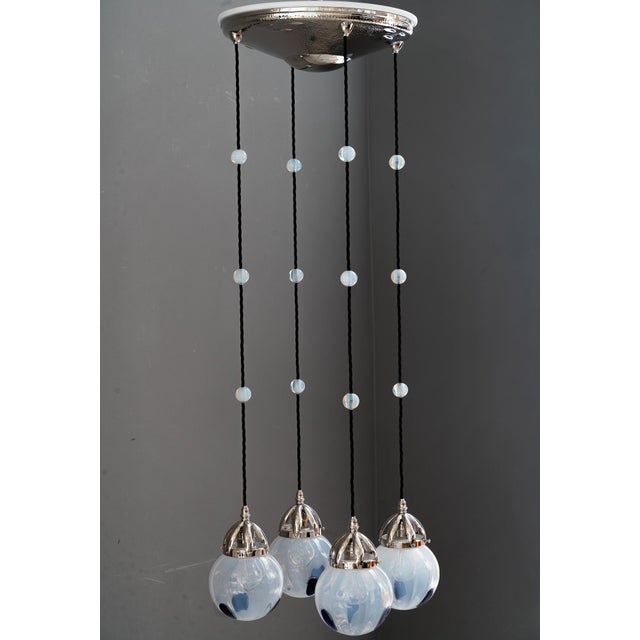 Koloman Moser attributed Bakalowits & Sohne chandelier hammered, with blue opaline glass lamp shades. The glass shades...