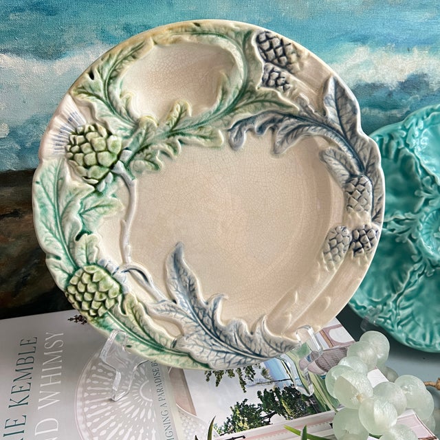 Set of 12 French majolica plates with artichoke design in pales shades of green and blue. Each plate has dimensional...