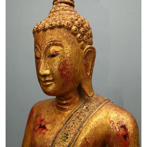 Elegant antique standing Thai Buddha figure, finely carved and richly gilded Depicted in a serene posture with hands...