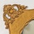 A stunning antique mirror with oval glass and rectangle frame with ornate corners and edges. Measures ~26" x 22". Has...