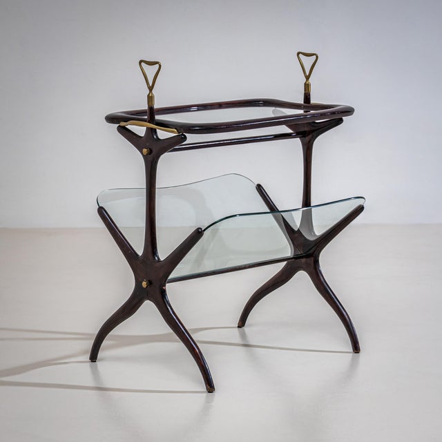 Side table with a removable tray featuring a glass bottom and brass handles. The lower section incorporates angled...