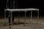 Heavy-duty embalming or preparation table featuring a porcelain enamel steel top set within a blackened steel perimeter...