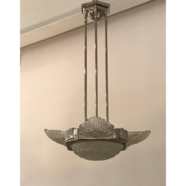 French Art Deco chandelier by Georges Leleu. Four clear frosted glass panels and center bowl with geometric motif. Held by...