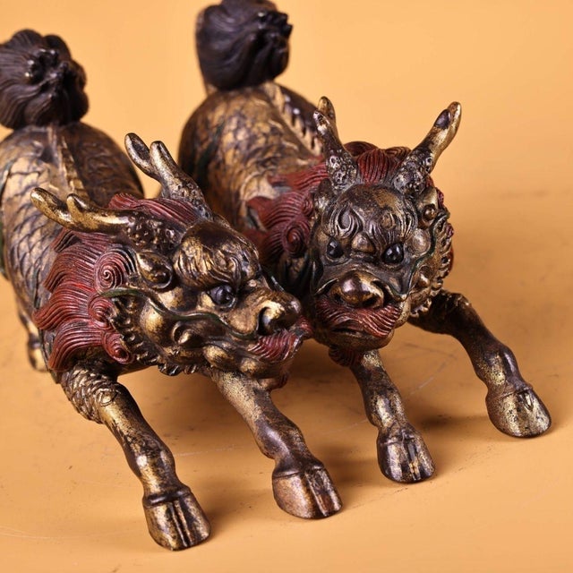 This is a matched pair of antique gilt bronze sculptures depicting Qilin, mythical hooved creatures revered in traditional...
