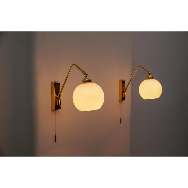 Pair of Large Mid-Century Modern Wall Lamps in Brass and Opaline Glass, 1950s The depth varies between 21 cm and 34 cm...