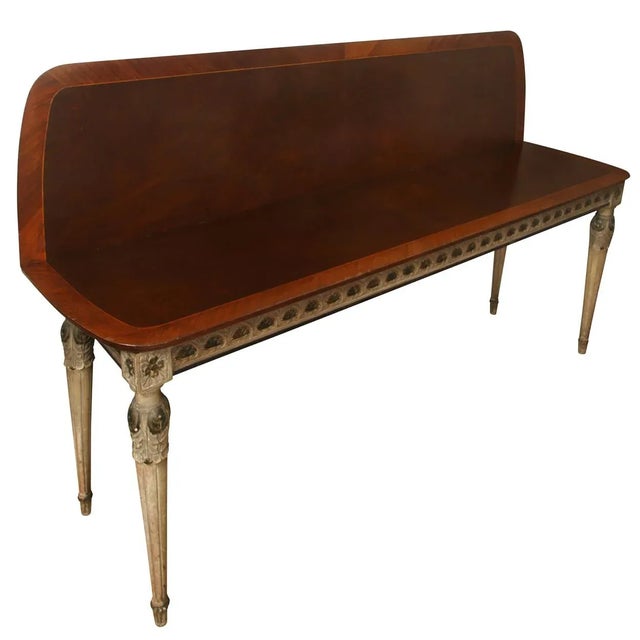 A metamorphic Neoclassical style console table with carved and painted detail. Dark wood top has a banded inlay border...