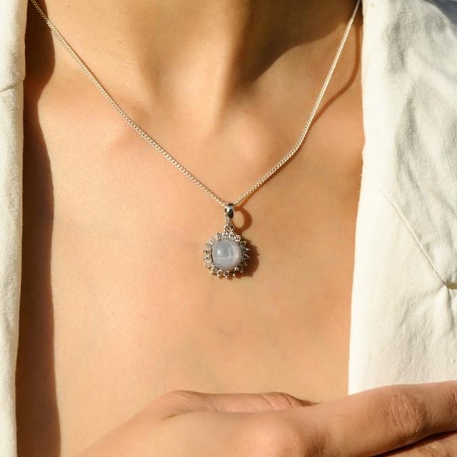 This elegant pendant features a round cut natural star sapphire totaling 4.65 carats, set in 14K white gold. The oval...