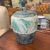 Studio pottery covered jar with a decorative band around the piece.. Abstract designs on this pottery make this piece pop....