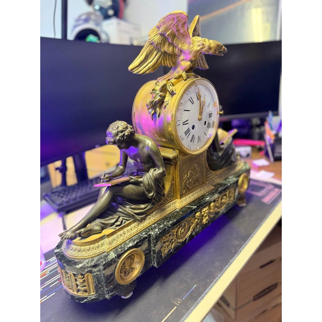 A fine quality gilt and patinated bronze library clock surmounted on a marble green base. Having a gilt bronze eagle...