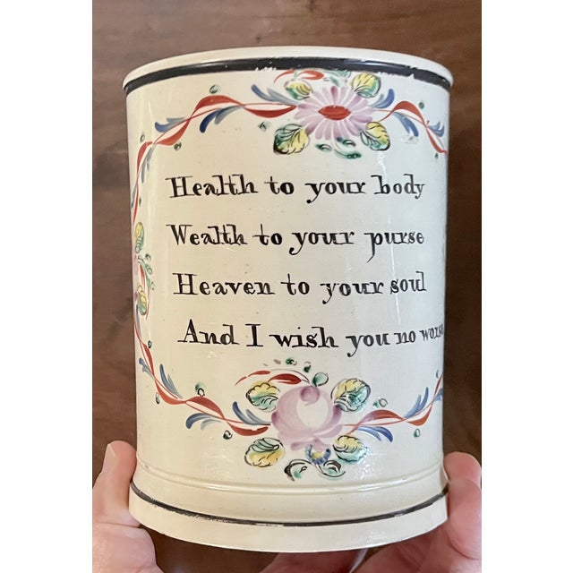 Antique late 18th century English creamware porter's tankard mug decorated with a motto and rose garland. Applied strap...