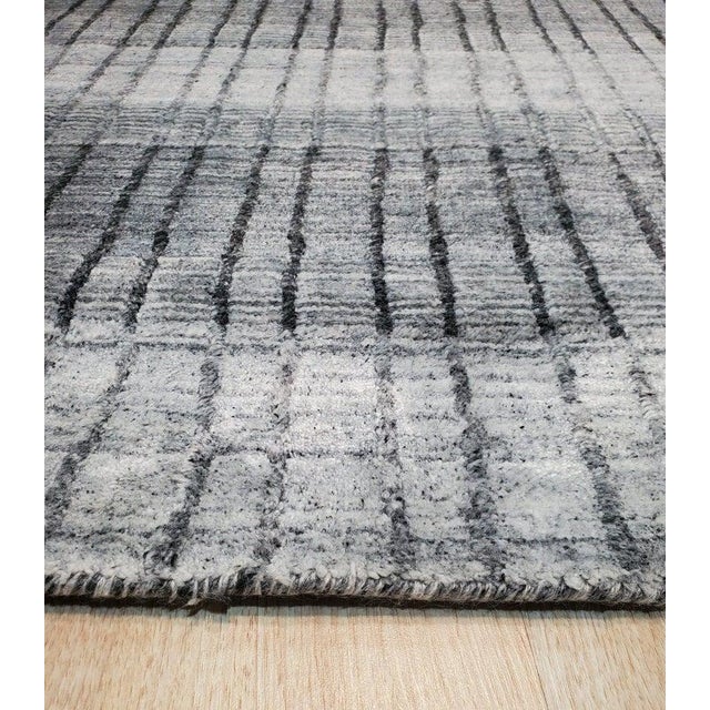 This gray contemporary rug features a hand knotted pile construction made from a blend of wool and viscose. Crafted in...