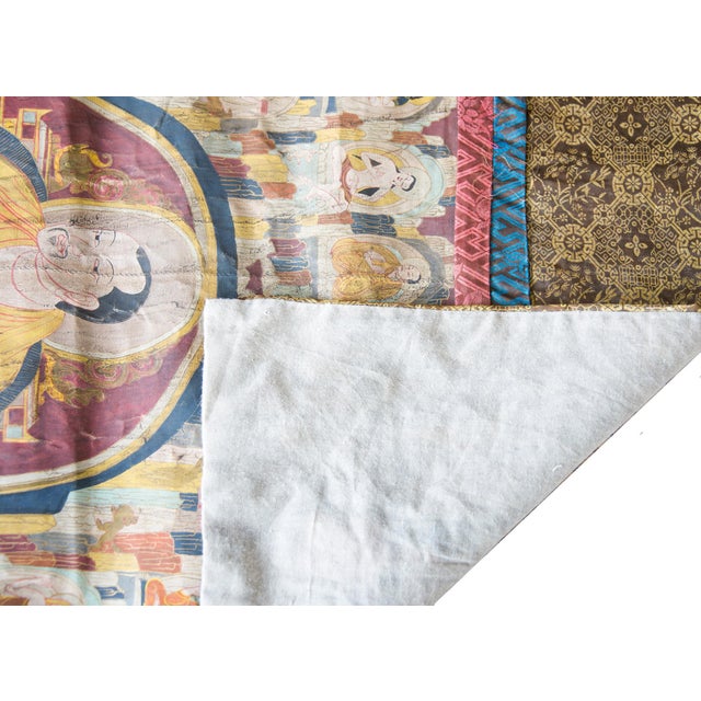 A wonderful late 19th century Tibetan Thangka depicting a portrait of a seated monk. Wearing the robes of a Tibetan...