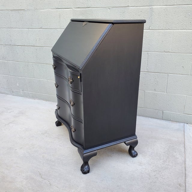 A classic secretary desk with ball & claw feet and serpentine front recently painted a low-sheen black with the interior...