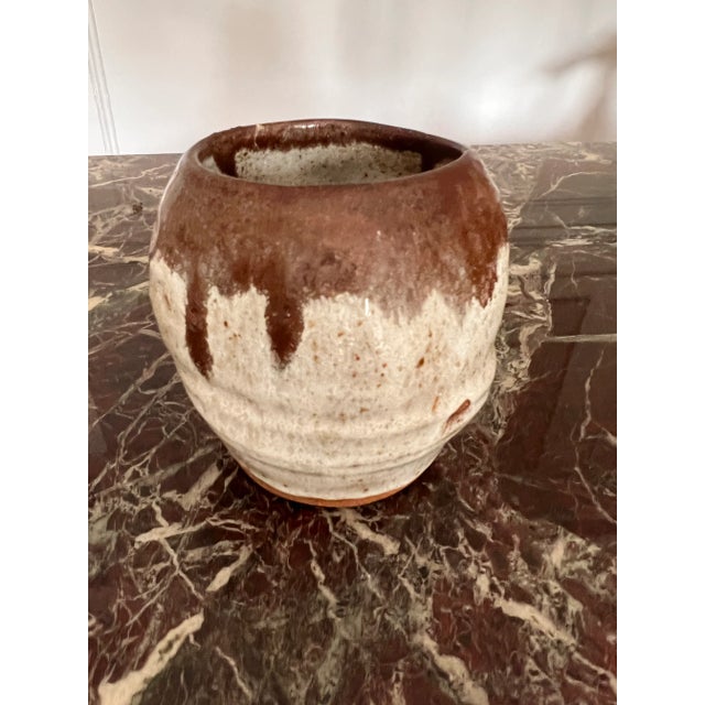 Beautiful ceramic vessel in brown and off-white color. Stunning glaze through the entire piece. Perfect for a floral...