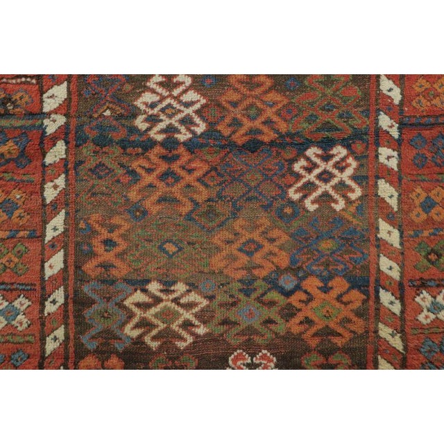 Hand-knotted in wool and originating circa 1900-1919, this 4x6 antique Persian rug features an allover field of repeating...