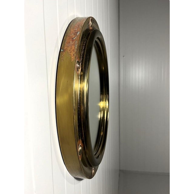 Brass porthole wall mirror by Vereinigte Werkstatten München, Germany. Brass frame in porthole design. 1950’s. In good...