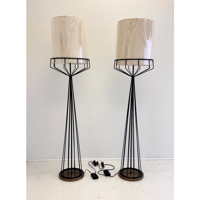 A striking pair of sculptural floor lamps based on an original design by Tony Paul. Constructed from slender black metal...