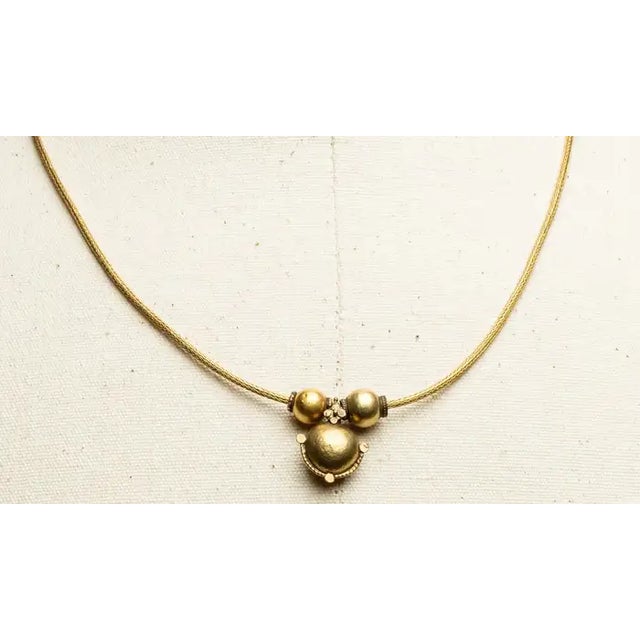A stunning, hand-rolled chain in 18K gold with a lovely, old Indian pendant and beads also in 18K gold. The clasp is a...