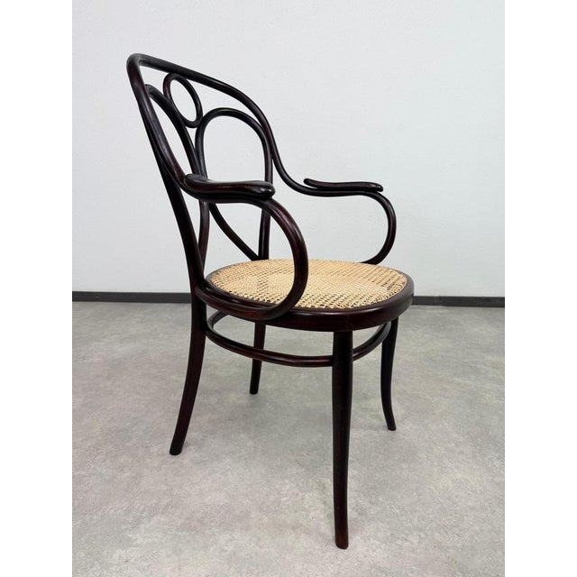 Beautiful and highly collectible antique bentwood armchair, manufactured by the legendary company Thonet (circa...