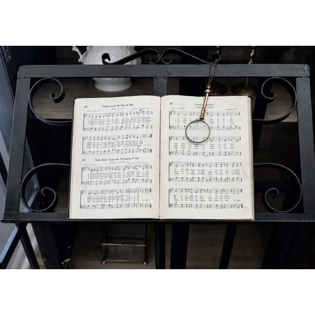 Substantial and beautifully balanced, this mid-century hand-forged wrought-iron music stand features intricate scrollwork...