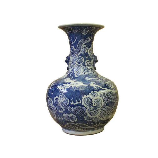 This is a Chinese decorative porcelain vase in Blue and White color finish. The theme is oriental dragons scenery graphic....