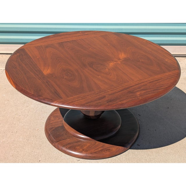 A striking Mid-Century Modern solid walnut coffee table featuring an exceptionally sculptural pedestal base and...
