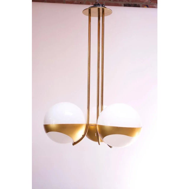 Impressive 1970s chandelier by Lamperti composed of three spherical milk glass shades housed in anodized aluminum...