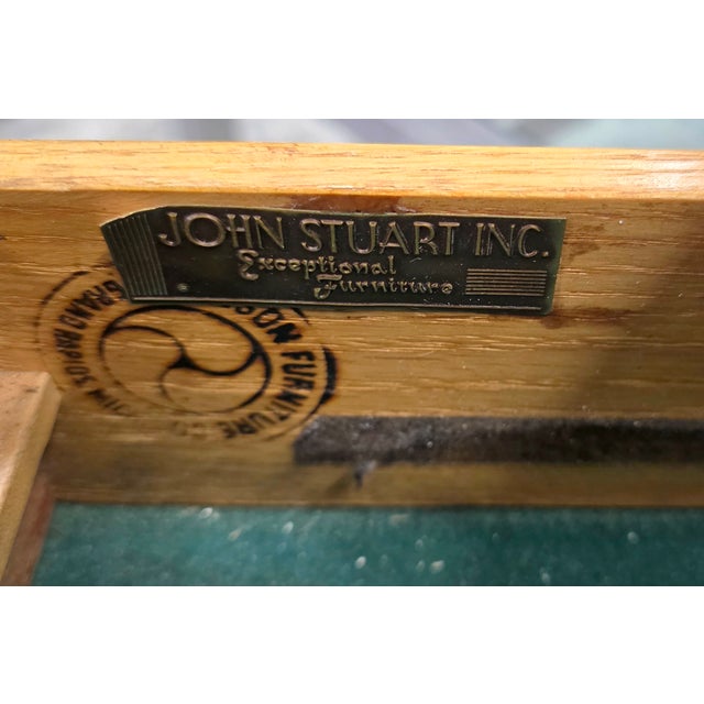 This Mid-Century John Stuart French Empire–Style Walnut Commode featuring a rectangular black marble top, has a...