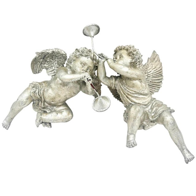Charming pair of vintage cherub shelf sitters featuring two playful putti angels blowing horns. Finished in an aged silver...