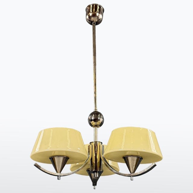 This Art Deco chandelier from the 1930s features a balanced metal structure combined with original opaline glass shades....