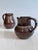 A pair of handcrafted jugs from the Serocka workshop, finished in their characteristic speckled brown and natural glazes...
