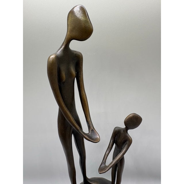 Fine Art Bronze Sculpture by renowned Burmese artist John Kennedy. This sculpture features a woman and child suggesting...