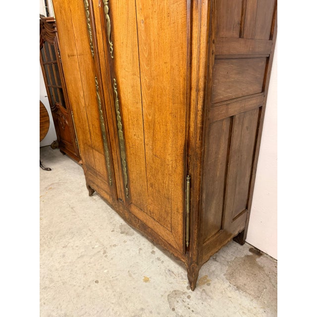 Impressive 18th-century French Louis XV style chestnut bonnet top armoire, dating to circa 1790, featuring a distinctive...