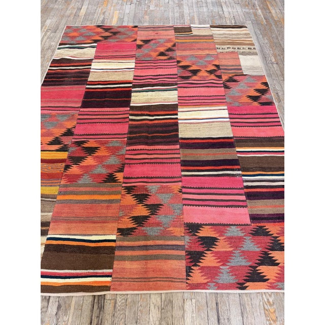 this early-20th-century Turkish Village Kilim is a captivating example of Anatolian tribal textile artistry. Handwoven...