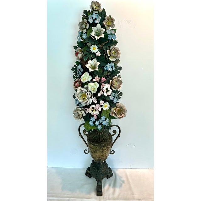 A striking pair of 19th-century tole (painted metal) and porcelain flower arrangements, of German or French origin. Each...