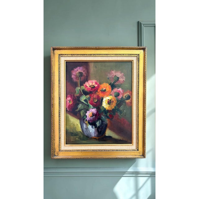An exceptionally decorative mid-century oil on canvas depicting a vibrant bouquet of ranunculus in a reflective pottery...