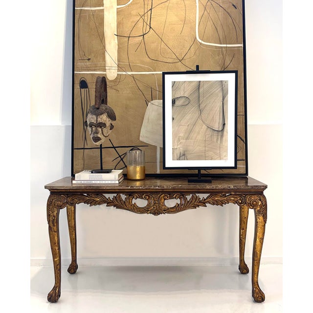 Italian Neoclassical / Louis XV style giltwood console, late 20th century, with Emperador marble top.” An elegant giltwood...