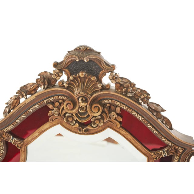 Mid-Century Modern gilt wood framed hanging wall beveled mirror with hand carved design details motif. The mirror is in...