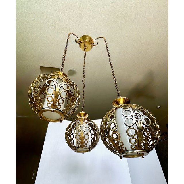An exceptional mid-century modern three-light cluster chandelier, heavily influenced by the glamour of the Hollywood...