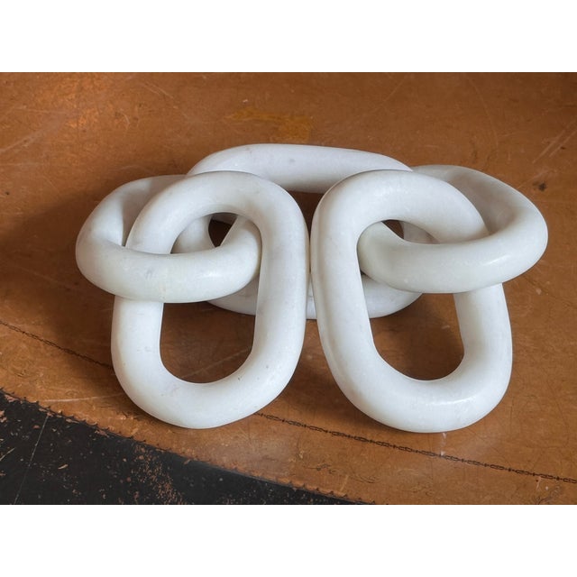 Alabaster chain of five interlocking oval links carved from a single block, the surfaces polished smooth with subtle grey...