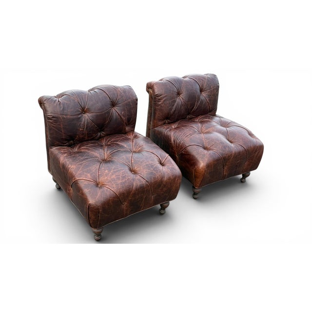 Wonderful and unusual pair of leather slipper chairs in the Chesterfield style. These are relatively smaller in scale than...
