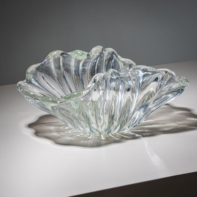 Glass bowl with a waved rim formed as a stylized flower. Its organic design and elegantly sculpted silhouette give the...