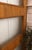 Mid-century paneled wood interior door featuring reeded glass inserts and warm grain. Subtle, age-appropriate wear...