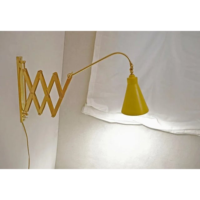 Extendable scissor wall lamp or wall lamp in brass, with switch on the wall support. Made in Italy in the 1940s Perfectly...