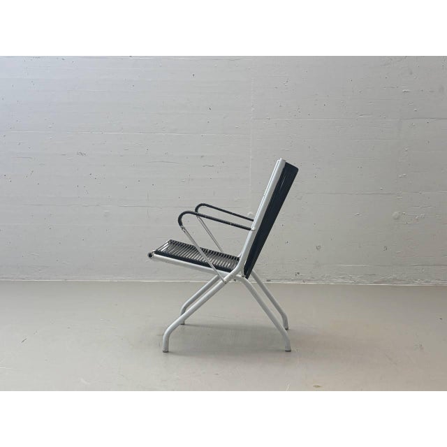 A rare french lounge chair by andré monpoix from the 1950s, featuring a striking, graphic design and a delicate metal...